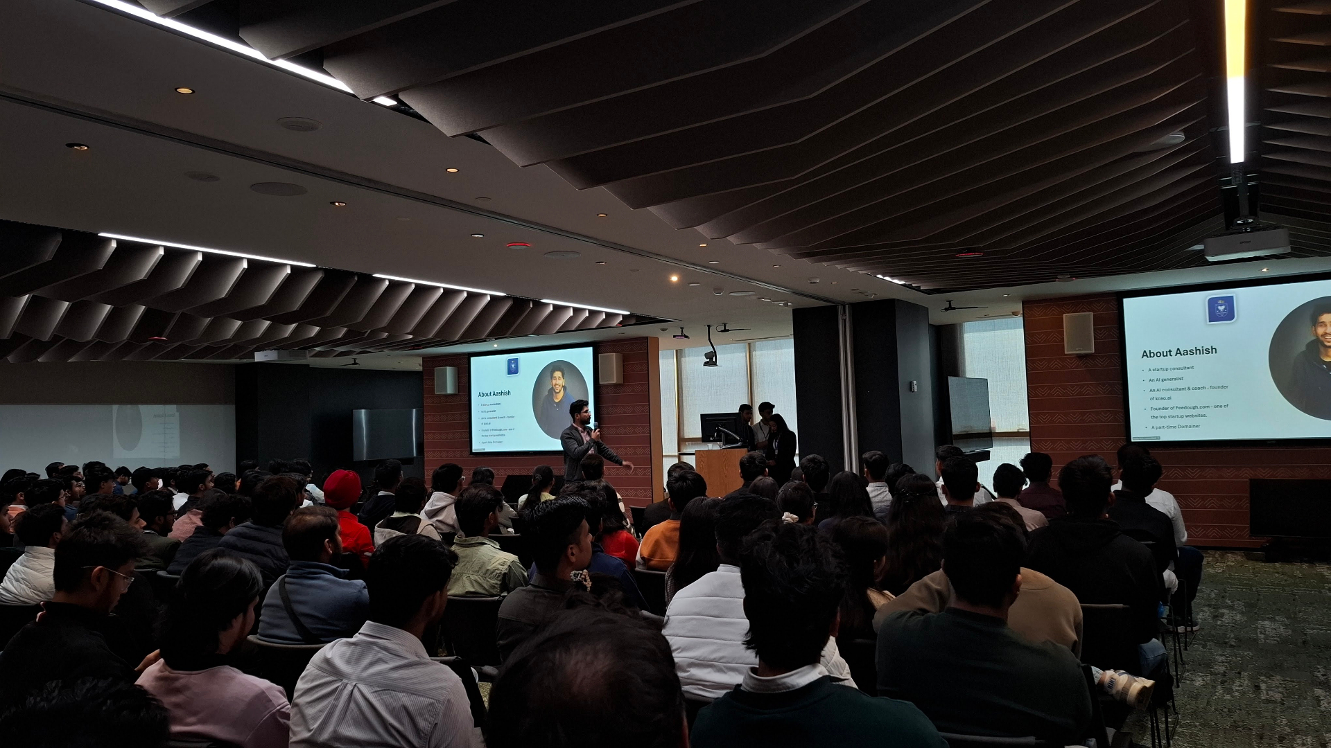 Aashish presenting About Aashish to a packed campus auditorium